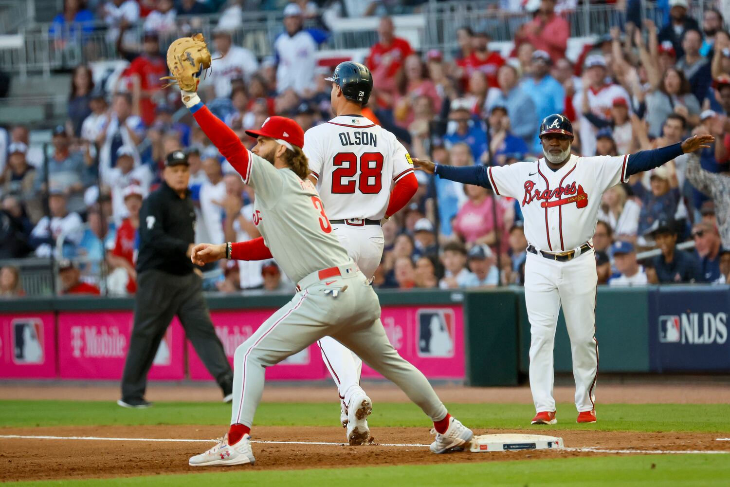 Atlanta Braves’ Matt Olson (28) beats out a throw to Philadelphia Phillies’ Bryce Harper (3) on a fielding error during the second inning of the NLDS Game 2 In Atlanta on Monday, Oct. 9, 2023.   (Miguel Martinez / Miguel.Martinezjimenez@ajc.com)