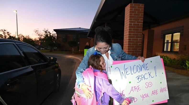 School counselor Carrie Poole gets a hug from kindergartener Ava Beverly as she is dropped off at Jeff Davis Primary School in Hazelhurst. Jeff Davis County Schools returned for the first time since Hurricane Helene devastated much of South Georgia. (Hyosub Shin/AJC 2024)