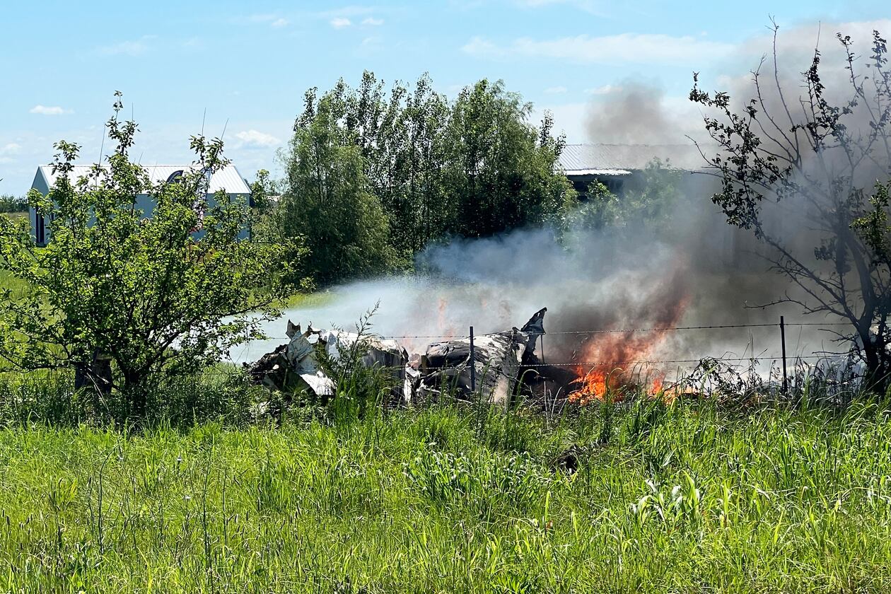The wreckage of a plane crash burns in a field in Butler, Mo, Sunday, June 14, 2026. (Mid America News Review via AP Photo )
