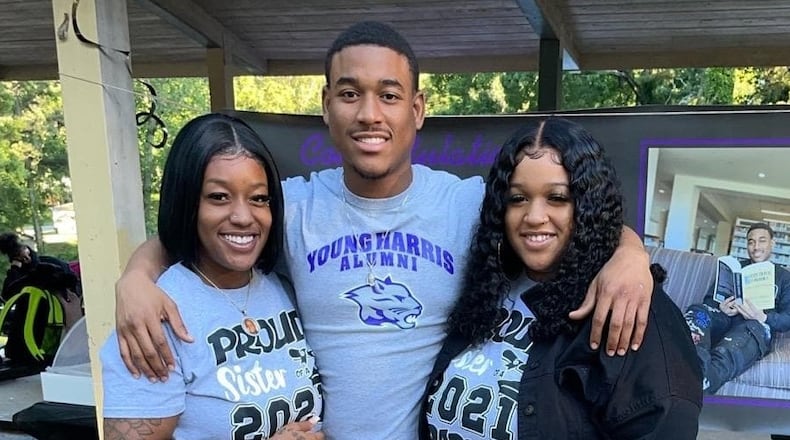 Artez Benton, center, and his sisters Arteria, left, and Bria after he graduated from Young Harris College last year.