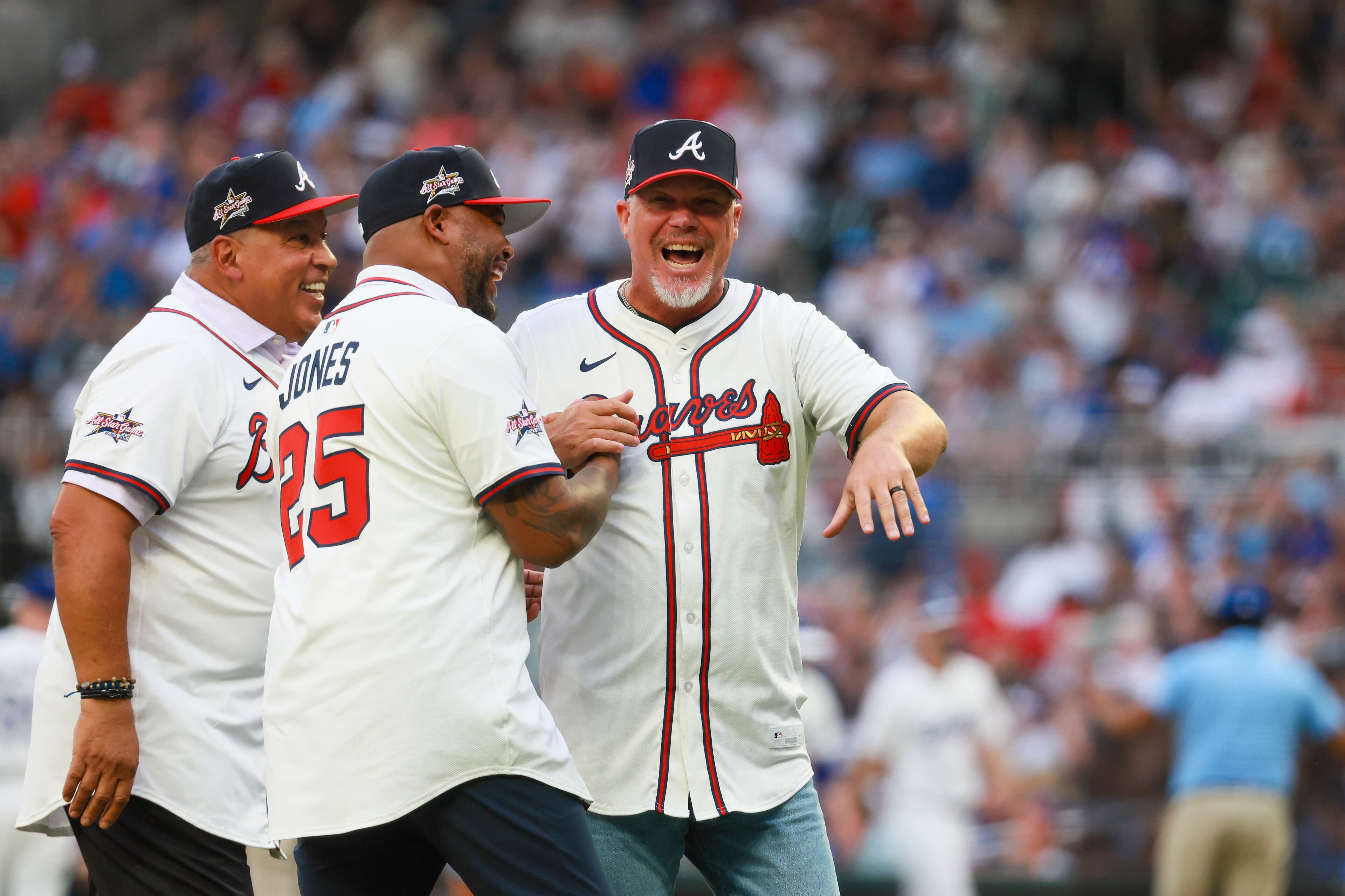 Atlanta Braves greats (from left) Andrés Galarraga, Andruw Jones and Chipper Jones celebrate the ceremonial first pitch thrown by Chipper Jones to help open the MLB All-Star Game at Truist Park in Atlanta on Tuesday, July 15, 2025. (Jason Getz/AJC)