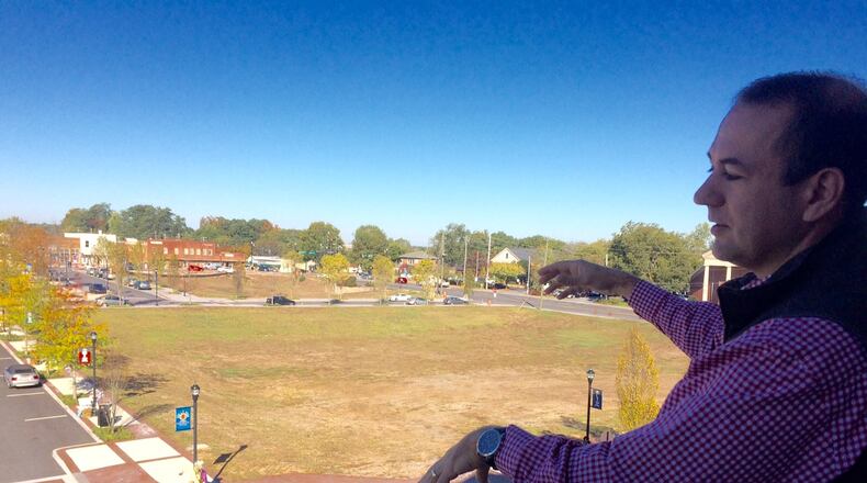 Alpharetta Mayor David Belle Isle stands on the balcony of the new City Hall and points out the new downtown he envisions. Photo by BILL TORPY