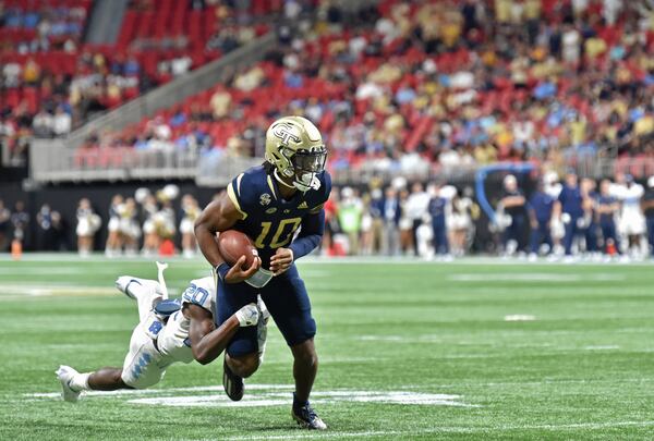 Georgia Tech quarterback Jeff Sims (10) gets tackled from behind by North Carolina defensive back Tony Grimes (20) during the second half Saturday, Sept. 25, 2021, at Mercedes-Benz Stadium in Atlanta. Tech won 45-22. (Hyosub Shin / Hyosub.Shin@ajc.com)