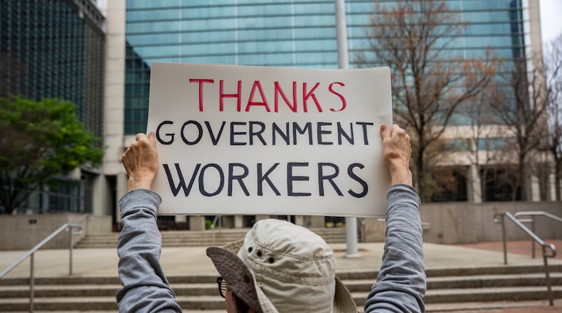 Former U.S. Centers for Disease Control employees applaud former U.S. Department of Education employees as they exit the Sam Nunn federal building in Atlanta on Wed., April 2, 2025, after the Trump administration recently reduced the department's workforce by 50%. (Olivia Bowdoin for the AJC).