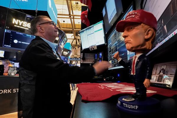 A Donald Trump bobblehead sits on the counter as trader Jonathan Mueller works on the floor of the New York Stock Exchange, Tuesday, April 22, 2025. (AP Photo/Richard Drew)