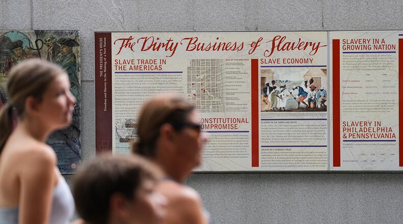 FILE - People walk past an informational panel at President's House Site Tuesday, Aug. 19, 2025, in Philadelphia. (AP Photo/Matt Rourke, File)