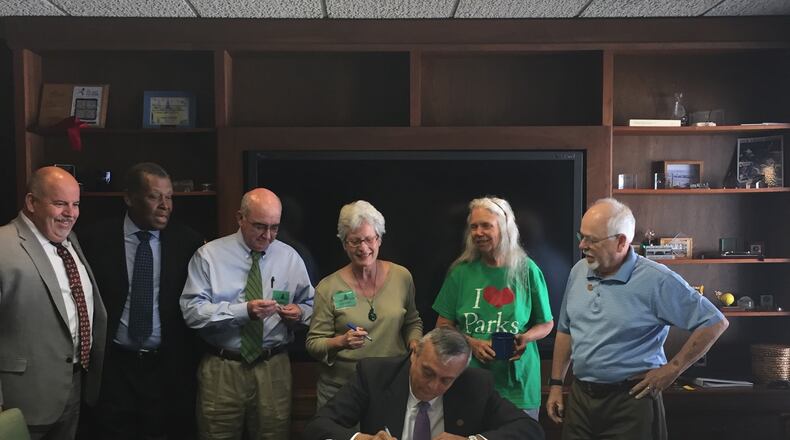 Cobb Commission Chairman Mike Boyce signs a document to execute Cobb County’s 2017 Series Parks Bond while other county officials and members of Cobb Parks Coalition look on. Courtesy of Cobb County