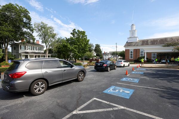 Automobiles line up to receive food during the weekly drive-up food pantry at First Presbyterian Church in Marietta on Tuesday. (Jason Getz/AJC)