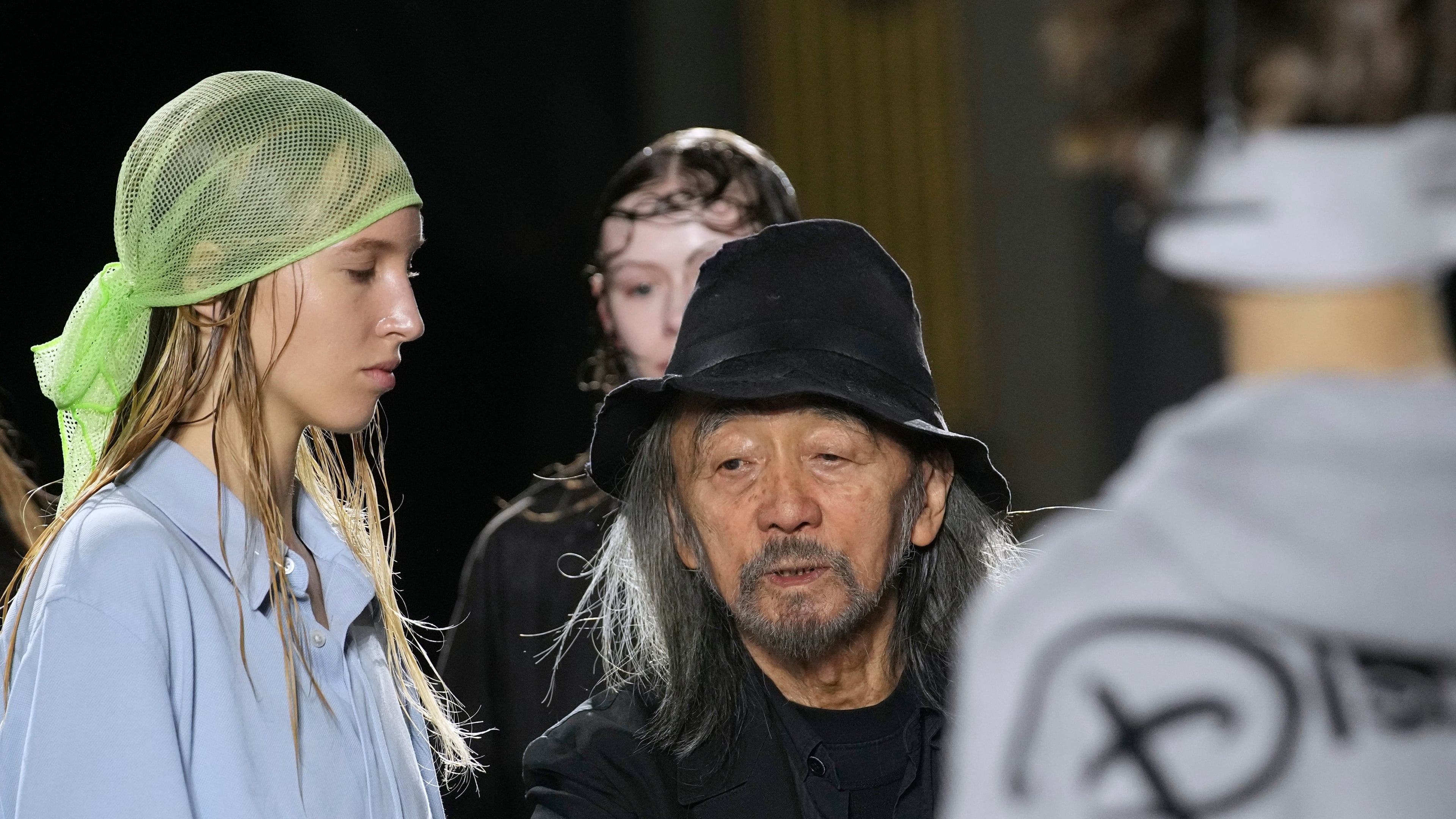 Designer Yohji Yamamoto speaks to models prior to the Yamamoto Spring/Summer 2026 collection presented in Paris, Friday, Oct. 3, 2025. (AP Photo/Christophe Ena)