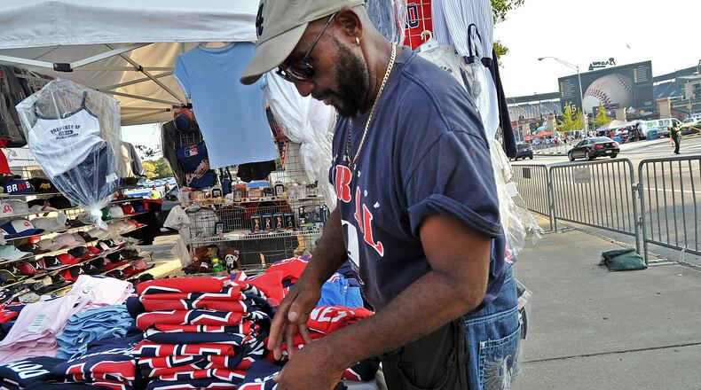 110830 Atlanta : Stanley Hambrick arranges shirts at his street vendor on Hank Aaron Blvd near Turner Field before the Atlanta Braves home game against the Washington Nationals on Tuesday, August 30, 2011. Larry Miller and Stanley Hambrick have been vending outside Turner Field for 30-plus years and are suing the city because Atlanta wants to put them inside four-by-nine foot metal kiosks. The two, they are rivals but also friends, currently vend hats, shirts, foam tomahawks and peanuts in 10-by-10 tents. Hyosub Shin, hshin@ajc.com