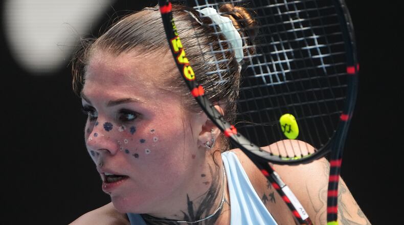 Oleksandra Oliynykova of Ukraine plays a backhand return to Madison Keys of the U.S. during their first round match at the Australian Open tennis championship in Melbourne, Australia, Tuesday, Jan. 20, 2026. (AP Photo/Asanka Brendon Ratnayake)