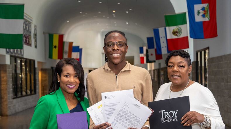 Douglas County High School principal Kenja Parks (from left), with senior Mantavius Lebron Presley and his mother, Chasity Green, in the school's "Great Hall" with some of his acceptance letters. PHIL SKINNER FOR THE ATLANTA JOURNAL-CONSTITUTION