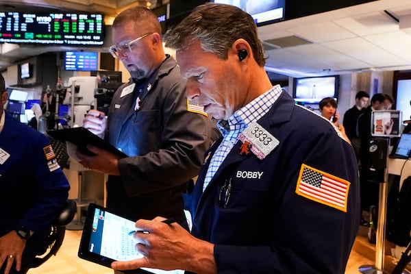 Traders Ryan Falvey, left, and Robert Charmak work on the floor of the New York Stock Exchange, Friday, June 27, 2025. (AP Photo/Richard Drew)