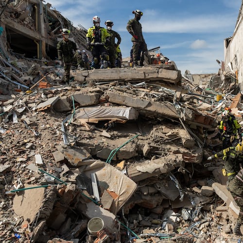 Rescuers carry the body of a victim from the rubble four days after after an earthquake hit Pereira, Colombia, Friday, Aug. 14, 2026. (AP Photo/Brandon Pinto)