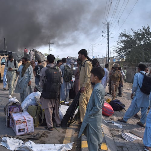 Volunteers look for victims from an overturned train coach on a railway track as survivors wait for transport at the site of bomb explosion, in Quetta, Pakistan, Sunday, May 24, 2026. (AP Photo/Arshad Butt)