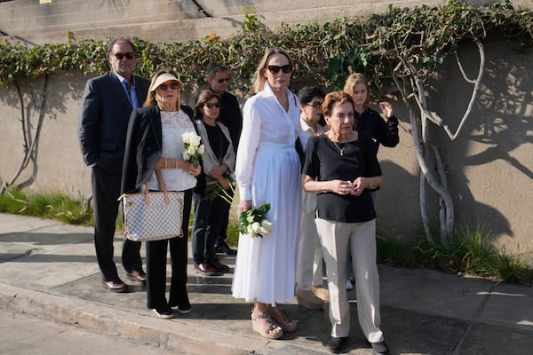Family and friends watch a hearse transport the coffin of Peruvian Nobel literature laureate Mario Vargas Llosa to a crematorium in Lima, Peru, Monday, April 14, 2025. (AP Photo/Martin Mejia)