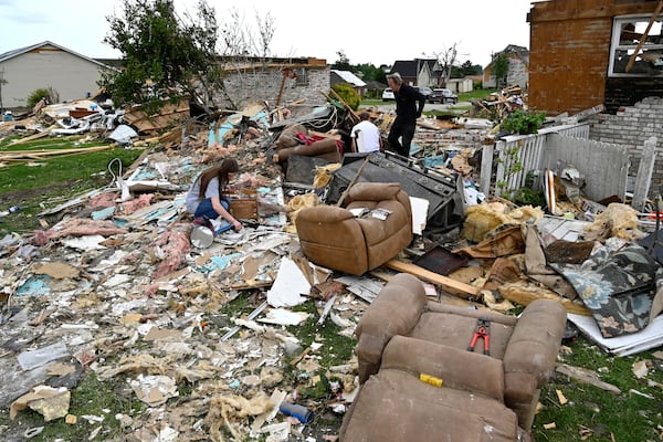 Volunteers help go through the remains of a home looking for what they could salvage in the Sunshine Hills neighborhood in London, Ky., Monday, May 19, 2025. (AP Photo/Timothy D. Easley)