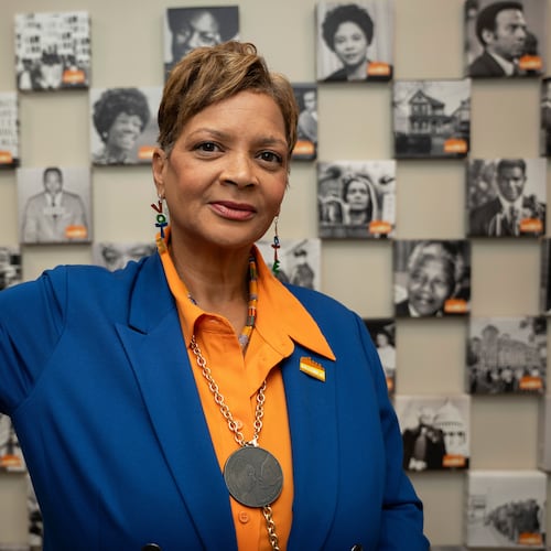 Deborah Scott, CEO of Georgia Stand-Up, raises her fist while standing in front of a wall honoring unsung heroes of the civil rights movement at The Movement Center, in Atlanta, Sunday, Nov. 30, 2025. (AP Photo/Olivia Bowdoin)