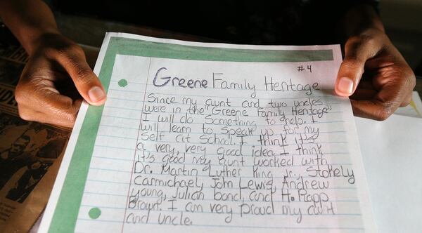 Sharena Johnson, 17, of Lawrenceville holds an essay she wrote for a civil rights family heritage project when she was a young Girl Scout. CURTIS COMPTON / CCOMPTON@AJC.COM