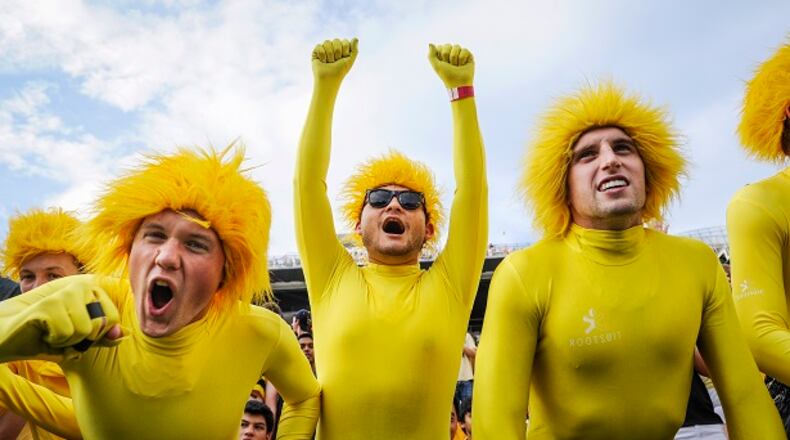 Georgia Tech students Joe Sobchuk, left, David Gaitan, and Matt Schwartz, right, cheer as their team comes on the field before the start of an NCAA college football game against Alcorn State, Thursday, Sept. 3, 2015, in Atlanta. (AP Photo/John Amis)