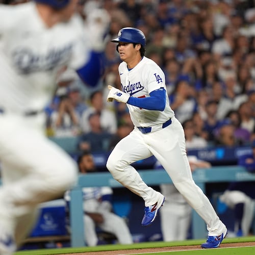 Los Angeles Dodgers' Shohei Ohtani (17) scores on an infield hit by Freddie Freeman (5) against the Seattle Mariners during the third inning of a baseball game Wednesday, July 29, 2026, in Los Angeles. (AP Photo/Scott Strazzante)