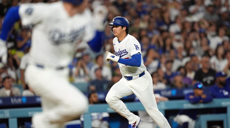 Los Angeles Dodgers' Shohei Ohtani (17) scores on an infield hit by Freddie Freeman (5) against the Seattle Mariners during the third inning of a baseball game Wednesday, July 29, 2026, in Los Angeles. (AP Photo/Scott Strazzante)