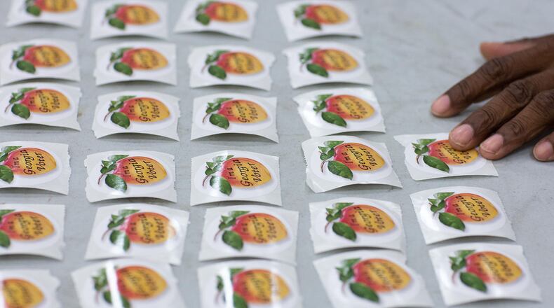 Poll worker DeCarlos Bennett lays out voting stickers at Grady High School in preparation for the primary runoff election, Tuesday, July 26, 2016, in Atlanta. BRANDEN CAMP/SPECIAL
