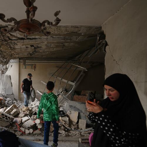 Fadi Al Zein, left, who lost both his homes in Israeli strikes in his village of Khiam and in Dahiyeh, searches through the rubble of his heavily damaged home as a child stands nearby, in Beirut's southern suburbs, Lebanon, Saturday, April 25, 2026. (AP Photo/Hassan Ammar)