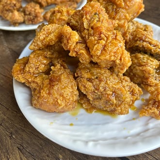 two orders of fried chicken on white plates