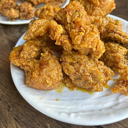 two orders of fried chicken on white plates