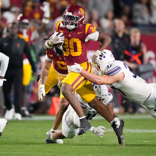Southern California running back King Miller, left, breaks a tackle by Northwestern linebacker Mac Uihlein during the first half of an NCAA college football game Friday, Nov. 7, 2025, in Los Angeles. (AP Photo/Mark J. Terrill)