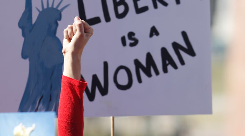 An unidentified participant raises her hand in support of a speaker during a march around the State Capitol to mark International Women's Day on Wednesday, March 8, 2017, in Denver. More than 1,000 women--and men--took part in the Denver march, one of many staged across the country by organizers of January's Women's March. The action called on women to stay home from work and not spend money in stories or online to show their economic clout on America's fabric. (AP Photo/David Zalubowski)