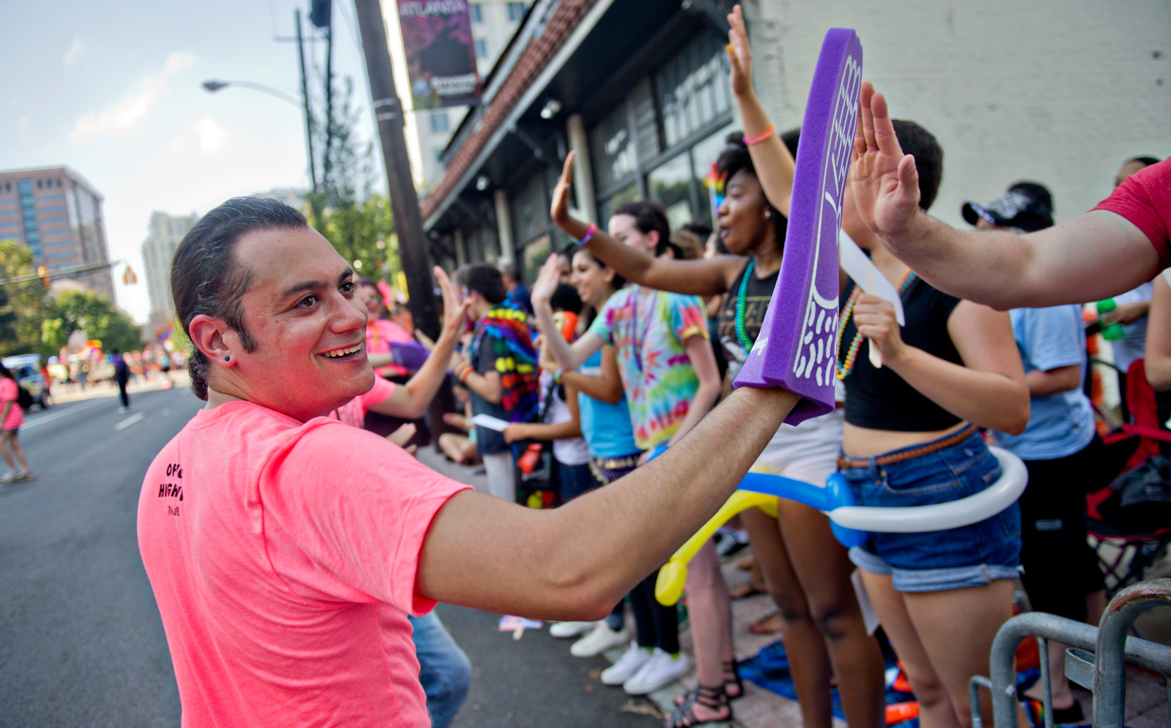 Jared van Aalten (left) gives out high fives as he marches during the Atlanta Pride Parade on Sunday, Oct. 12, 2014. JONATHAN PHILLIPS / SPECIAL