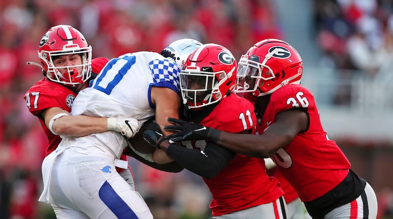 Kentucky wide receiver Chauncey Magwood (10) is stopped by Georgia defensive back Dan Jackson (47), defensive back Derion Kendrick (11), and defensive back Latavious Brini (36) as he carries the ball during the second half of an NCAA college football game Saturday, Oct. 16, 2021 in Athens, Ga. (AP Photo/Butch Dill)