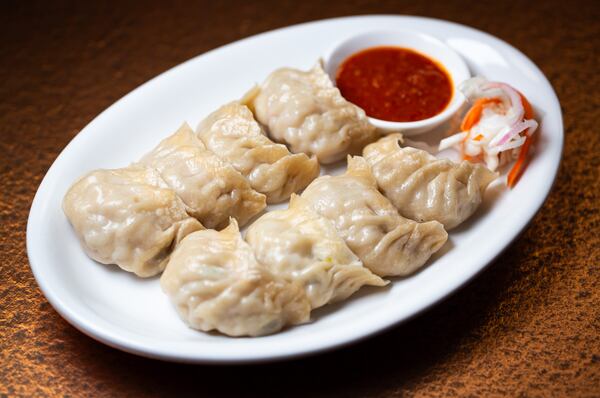 Tibetan potato steam momo is served with an accompanying spicy dipping sauce at Himalayan Kitchen. (Ryan Fleisher for the AJC 2024)