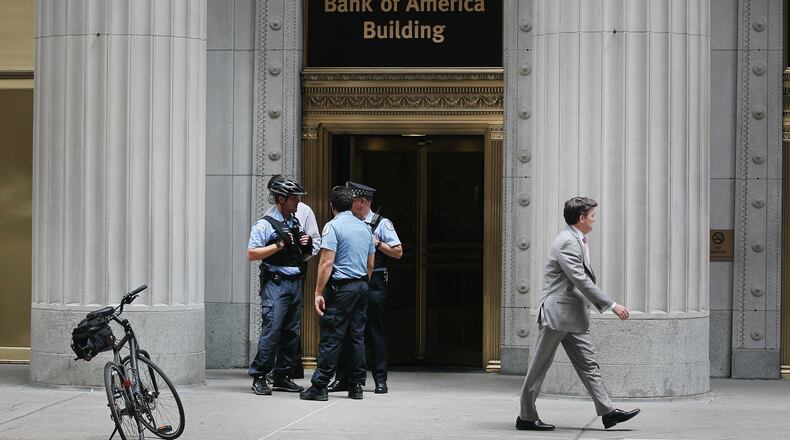 CHICAGO, IL - JULY 31: Chicago Police stand guard outside the Bank of America Building in the Loop financial district following a shooting on July 31, 2014 in Chicago, Illinois. Early reports indicate the shooter was a 59-year-old executive who was being demoted at his company. He shot the 54-year-old company CEO twice, critically wounding him, before shooting and killing himself. (Photo by Scott Olson/Getty Images)