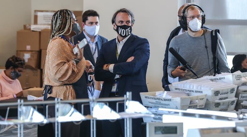 Fulton elections head Richard Barron (center) looks over operations as Fulton County election workers were hard at it Nov. 5, 2020 counting ballots at State Farm Arena. (John Spink / John.Spink@ajc.com)