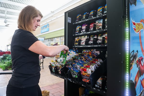 Kristen Albert restocks her Hot Wheels vending machine at The Outlet Shoppes in Woodstock on Friday, June 12, 2026. Albert said she loves the surge of fun vending machines around metro Atlanta. (Abbey Cutrer/AJC)