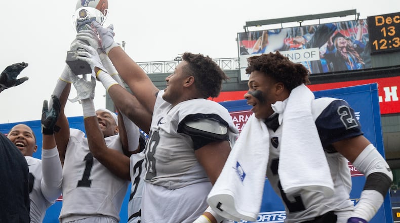 Eagle's Landing Christian Academy players hold up the trophy after beating Wesleyan High School during the Class A private state title football championship game at Georgia State Stadium Friday, December 13, 2019. STEVE SCHAEFER / SPECIAL TO THE AJC