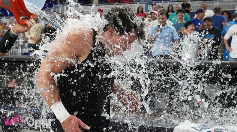 Miami Marlins' Griffin Conine, right, is doused after hitting a walk off single to defeat the Philadelphia Phillies in the the ninth inning of a baseball game, Monday, July 27, 2026, in Miami. (AP Photo/Lynne Sladky)