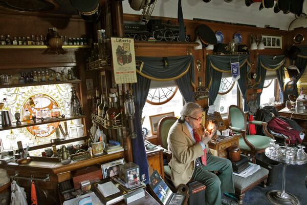 Dante Stephensen lights his pipe in The Survivor, the old luxury rail car he called home. It is packed with memories of his four decades at Dante's Down the Hatch, the iconic Atlanta restaurant.