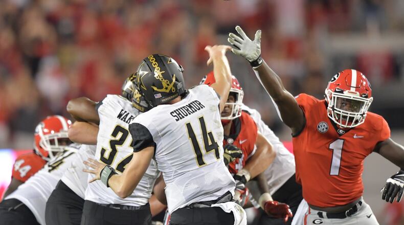 Georgia's Brenton Cox (right) pressures Vanderbilt quarterback Kyle Shurmur. HYOSUB SHIN / HSHIN@AJC.COM