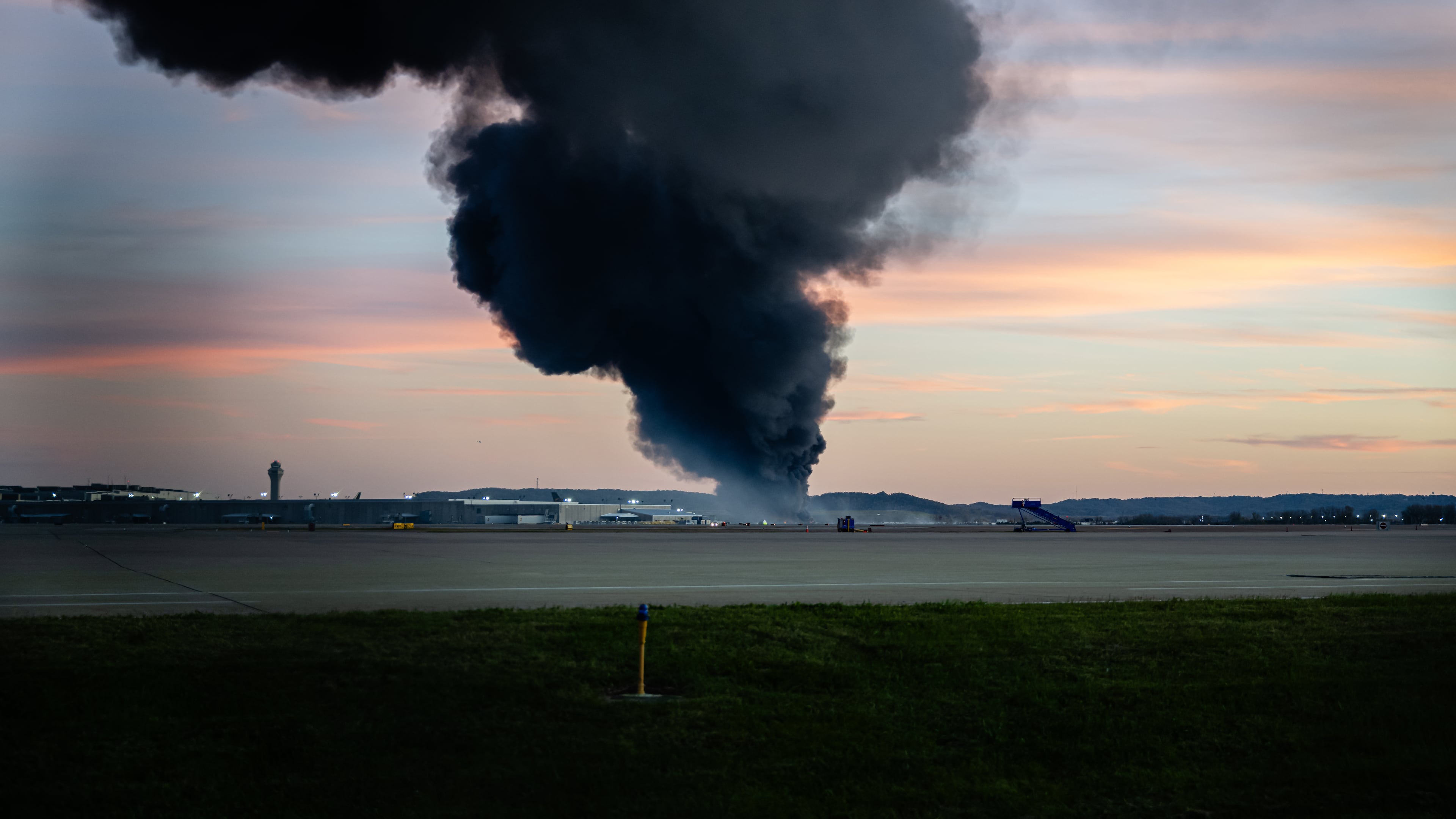 A plume of smoke rises from the site of a UPS cargo plane crash at Louisville Muhammad Ali International Airport on Tuesday, Nov. 4, 2025, in Louisville, Ky. (Jon Cherry/AP)