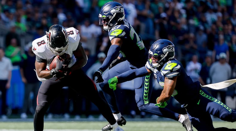 Seattle Seahawks safety Quandre Diggs, right, and cornerback Tariq Woolen try to catch Atlanta Falcons tight end Kyle Pitts as he picks up a long gain during the second quarter, Sunday, Sept. 25, 2022, at Lumen Field in Seattle. (Jennifer Buchanan/The Seattle Times/TNS)
