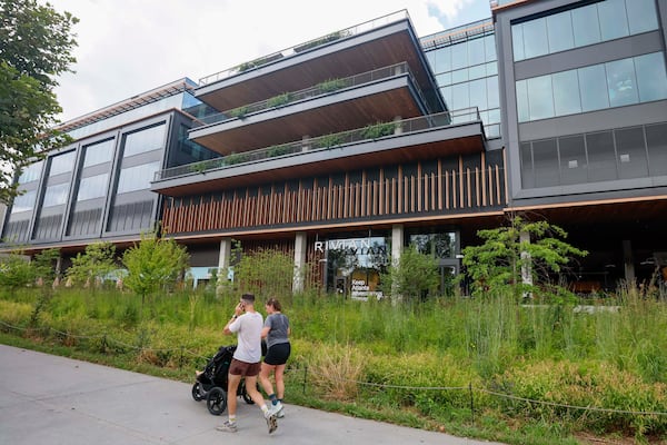 People on the Beltline walk past the Rivian headquarters building in Atlanta on Tuesday, Aug. 4, 2026. Rivian’s headquarters has 130 employees and is expected to grow to 500 by 2030. (Miguel Martinez/AJC)