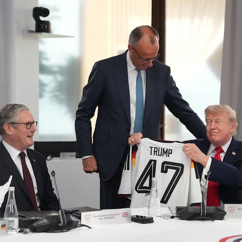 U.S. President Donald Trump, right, holds up a jersey with the number 47 on it as British Prime Minister Keir Starmer, left, and German Chancellor Friedrich Merz look on during a working session at the G7 summit in Evian-les-Bains, France, Tuesday, June 16, 2026. (AP Photo/Thibault Camus, Pool)