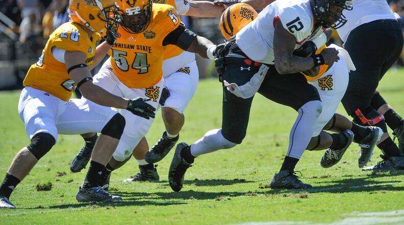 Kennesaw State linebacker Kyron Minter (54) tries to hold on to Gardner-Webb quarterback Tyrell Maxwell (12) as defensive back Taylor Henkle (26) also defends during the first half of an NCAA college football game, Saturday, Oct. 17, 2015, in Kennesaw, Ga. (Photo/John Amis)