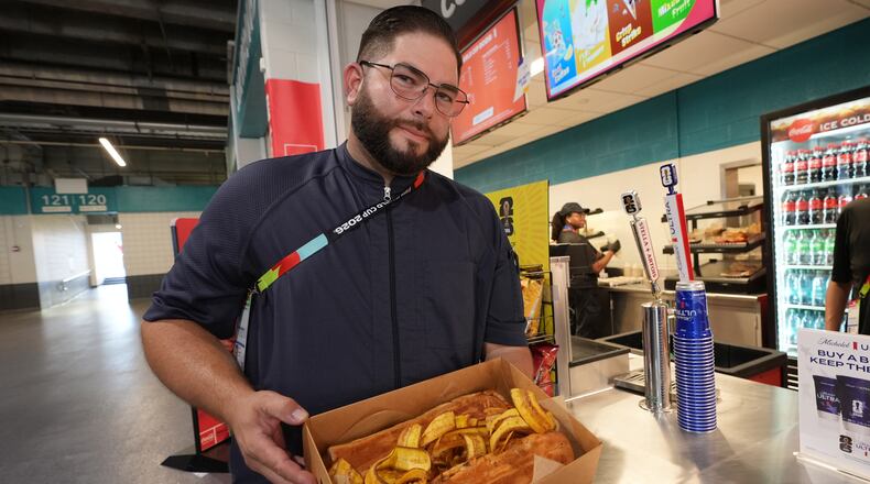 Lazaro Luya, the concession chef at Sol Cubano, displays their special, pan with lechon and fresh mariquitas at Miami Stadium Sunday, June 21, 2026, in Miami Gardens, Fla. (AP Photo/Marta Lavandier)