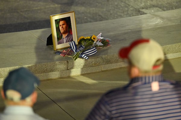 A photograph of conservative activist Charlie Kirk is placed at a vigil at Georgia Tech’s Campanile Fountain on Thursday. The event was hosted by Tech’s chapter of Turning Point USA. (Daniel Varnado/For the AJC)