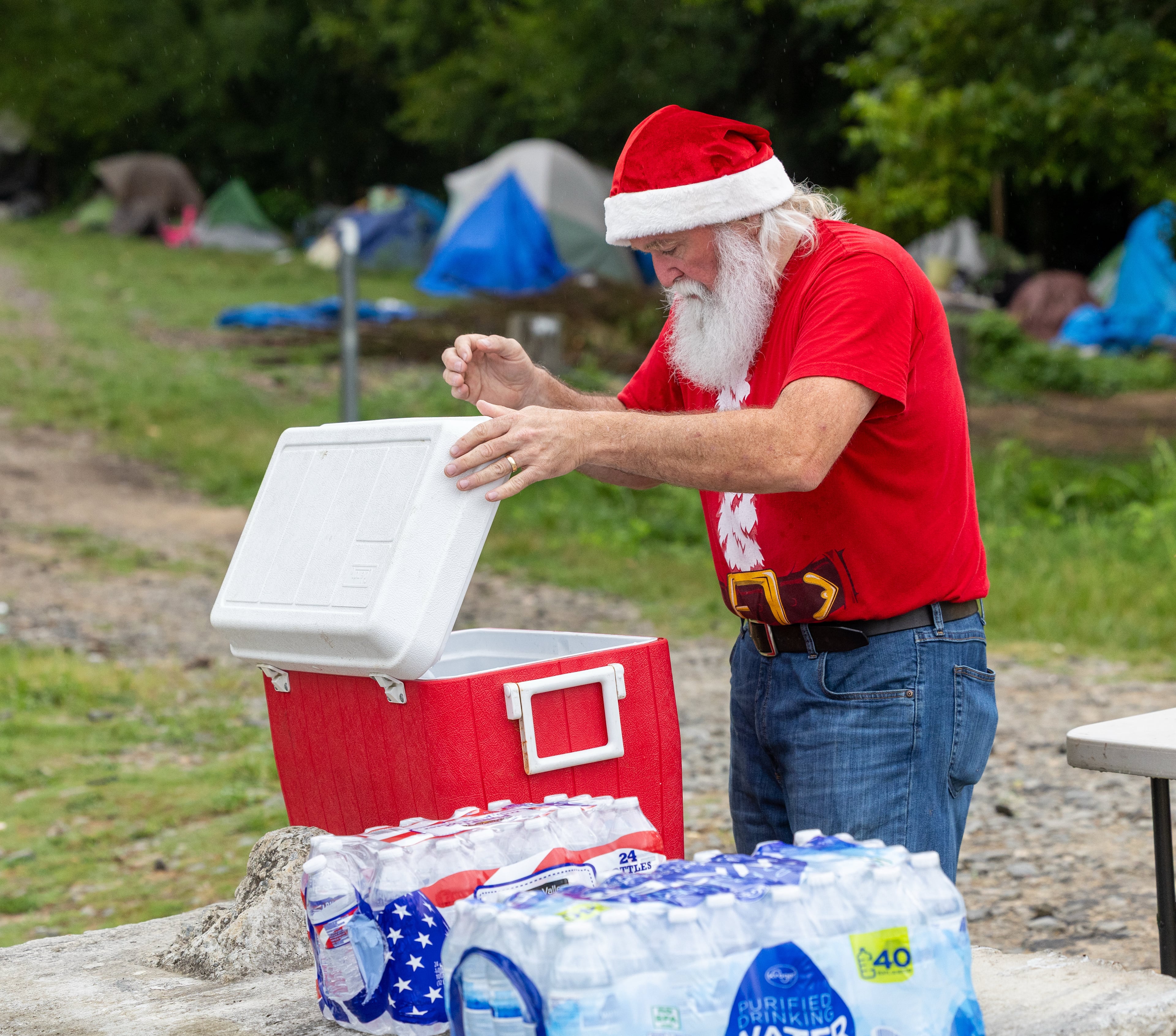 Randy Smith, aka "Santa Randy," checks out the supplies that have been delivered from churches and other organizations that he will help hand out around the homeless encampment in Gainesville. (Phil Skinner for the AJC)